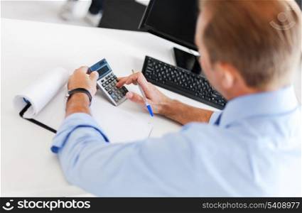 business, office, school and education concept - businessman with notebook and calculator