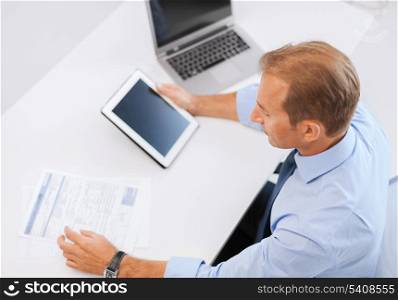 business, office, school and education concept - businessman with tablet pc and papers in office