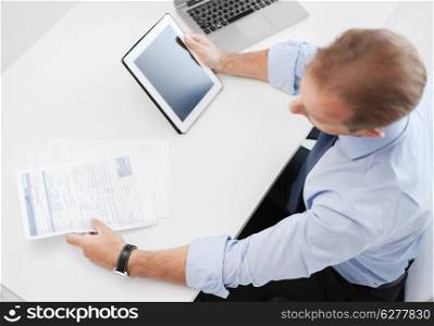 business, office, school and education concept - businessman with tablet pc and papers in office
