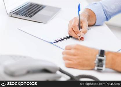 business, office, school and education concept - businessman writing in notebook