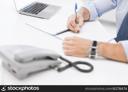 business, office, school and education concept - businessman writing in notebook