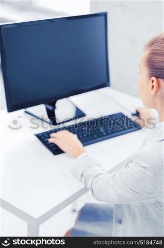 business, office, school and education concept - businesswoman on computer with blank screen in office. businesswoman with computer in office