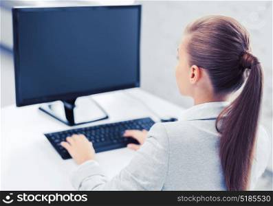 business, office, school and education concept - businesswoman on computer with blank screen in office. businesswoman with computer in office