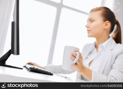 business, office, school and education concept - businesswoman with computer in office drinking coffee