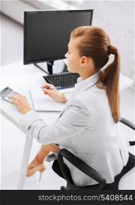 business, office, school and education concept - businesswoman with notebook and calculator