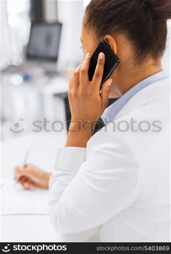 business, office, school and education concept - businesswoman with smartphone and papers