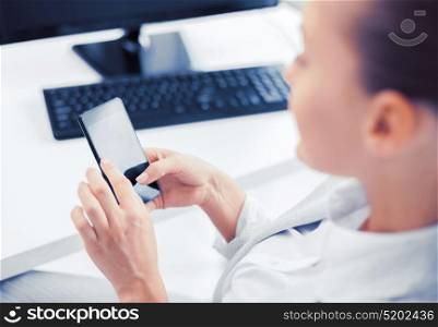 business, office, school and education concept - businesswoman with smartphone in office. businesswoman with smartphone in office