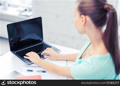 business, office, school and education concept - businesswoman working on laptop with blank screen. businesswoman with laptop computer in office