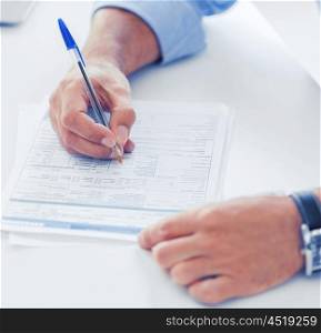 business, office, school and education concept - man filling tax form