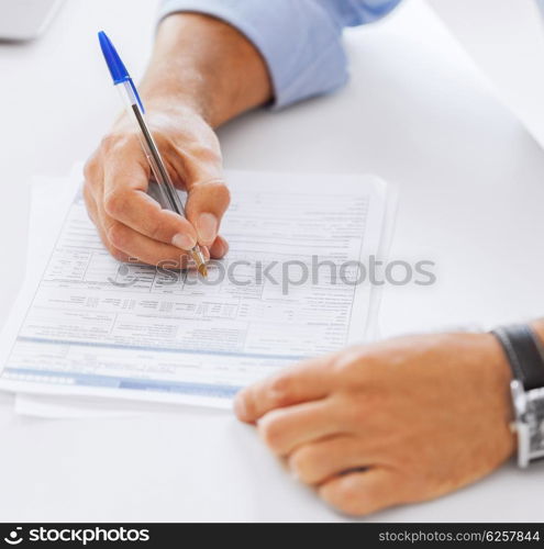 business, office, school and education concept - man filling tax form