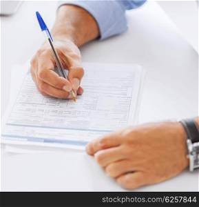 business, office, school and education concept - man filling tax form