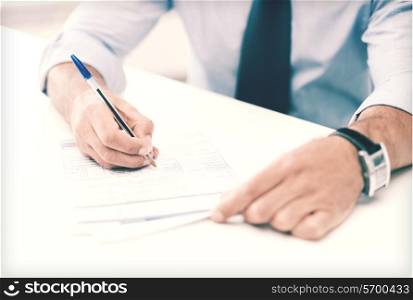 business, office, school and education concept - man signing a contract