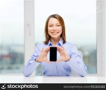 business, office, school and education concept - smiling businesswoman with black blank smartphone screen in office