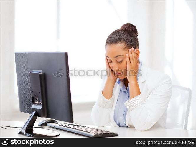 business, office, school and education concept - stressed african businesswoman with computer at work
