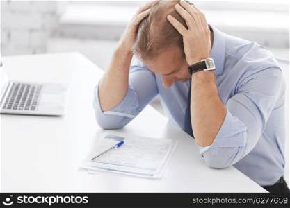 business, office, school and education concept - stressed businessman with papers at work