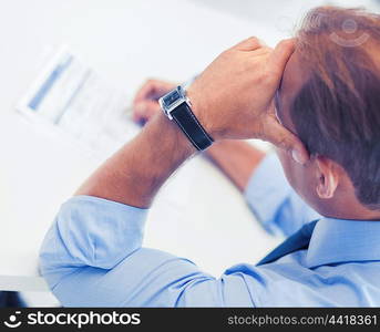 business, office, school and education concept - stressed man filling tax form