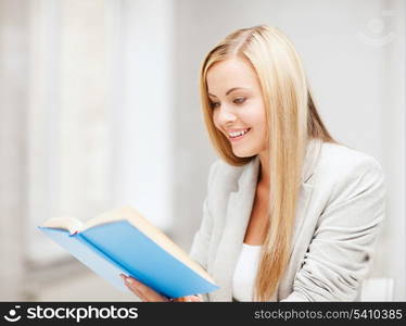 business, office, school and education concept - young woman reading book at school