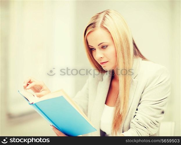 business, office, school and education concept - young woman reading book at school