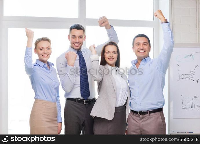 business, office, success and victory concept - happy business team celebrating victory in office