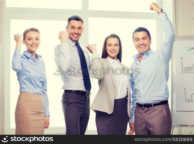 business, office, success and victory concept - happy business team celebrating victory in office