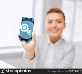 business, office, technology and education concept - close up of businesswoman or student showing settings icon on smartphone screen