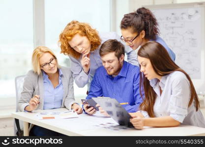 business, office, technology and startup concept - creative team with papers and clipboard working at office