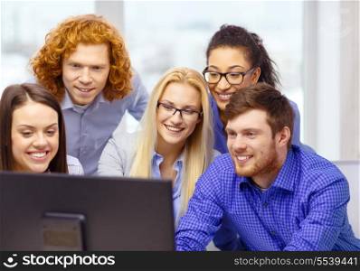 business, office, technology and startup concept - smiling business team looking at computer monitor at office