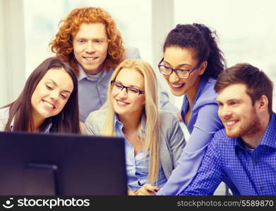 business, office, technology and startup concept - smiling business team looking at computer monitor at office