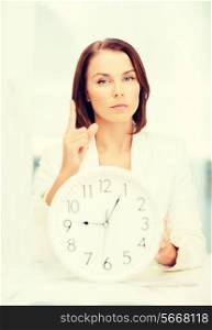 business, office, time management, deadline and education concept - attractive businesswoman showing clock