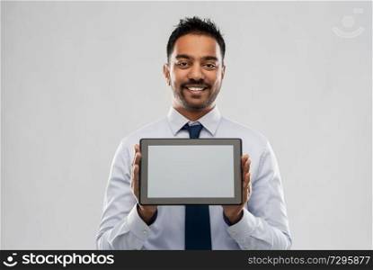 business, office worker and people concept - smiling indian businessman with tablet pc computer over grey background. indian businessman with tablet pc computer