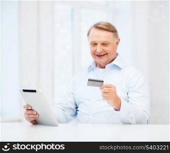 business, oldness, online banking, internet shopping and oldness concept - smiling old man with tablet pc and credit card at home
