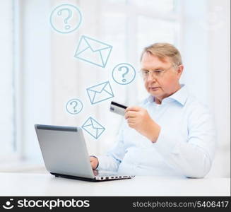 business, online banking, internet shopping and oldness concept - smiling old man with laptop computer and credit card at home