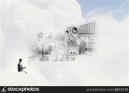 Business online. Young businessman sitting on cloud with mobile phone in hand