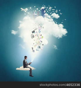 Business online. Young businessman sitting on cloud with mobile phone in hands