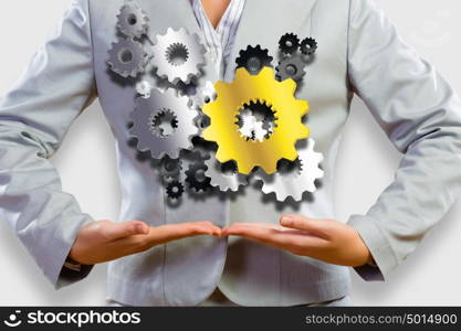 Business organization. Close up image of businesswoman holding gears in hands