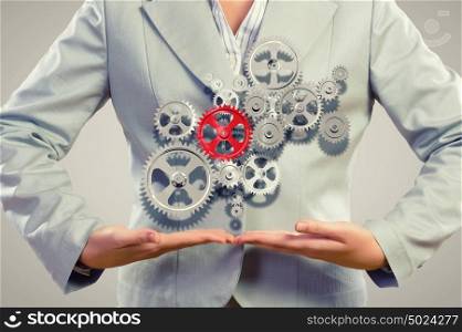 Business organization. Close up image of businesswoman holding gears in hands