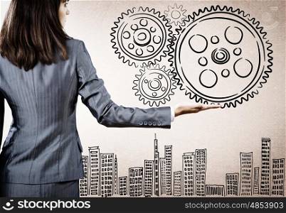 Business organization. Rear view of businesswoman holding gears in palm