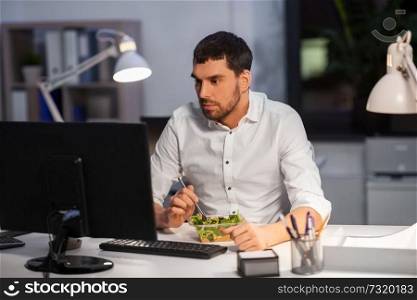 business, overwork, deadline and people concept - businessman with computer eating at night office. businessman with computer eating at night office
