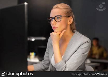 business, overwork, deadline and people concept - businesswoman in glasses working at computer in night office. businesswoman working at computer in night office