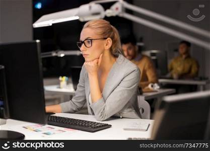 business, overwork, deadline and technology concept - businesswoman in glasses working at computer in night office. businesswoman working at computer in night office