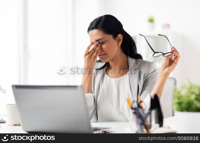 business, overwork, deadline, vision and people concept - tired businesswoman in glasses working at office and rubbing eyes. businesswoman rubbing tired eyes at office