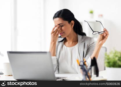 business, overwork, deadline, vision and people concept - tired businesswoman in glasses working at office and rubbing eyes. businesswoman rubbing tired eyes at office