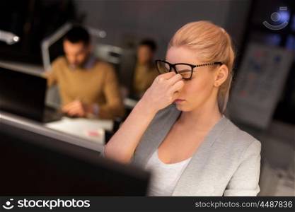 business, overwork, deadline, vision and people concept - tired businesswoman with glasses working late at night office and rubbing eyes. businesswoman rubbing tired eyes at night office. businesswoman rubbing tired eyes at night office
