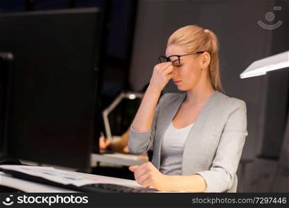 business, overwork, deadline, vision and people concept - tired businesswoman with glasses working late at night office and rubbing eyes. businesswoman rubbing tired eyes at night office