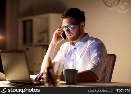 business, overwork, people, deadline and technology concept - businessman in glasses with laptop computer calling on smartphone at night office. businessman calling on smartphone at night office