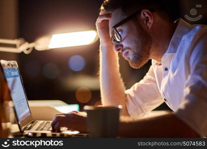 business, overwork, people, deadline and technology concept - stressed businessman in glasses with laptop computer typing at night office. businessman typing on laptop at night office