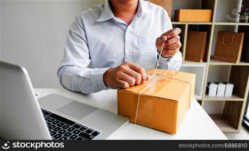 Business owner man working online shopping prepare product packaging process at his home, young entrepreneur concept