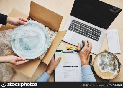 Business owner packing online order to delivery to customer. Preparing parcel box with ceramic plate product from online shop