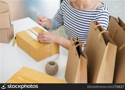 Business owner woman working online shopping prepare product packaging process at her home, young entrepreneur concept