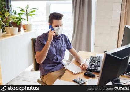 business, pandemic and health concept - businessman or creative male office worker wearing face protective medical mask for protection from virus disease with computer calling on smarphone. male office worker in mask calling on smarphone